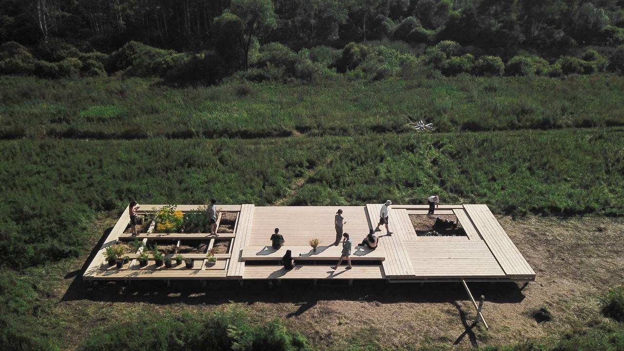 Wooden deck pavilion in a meadow, aerial view