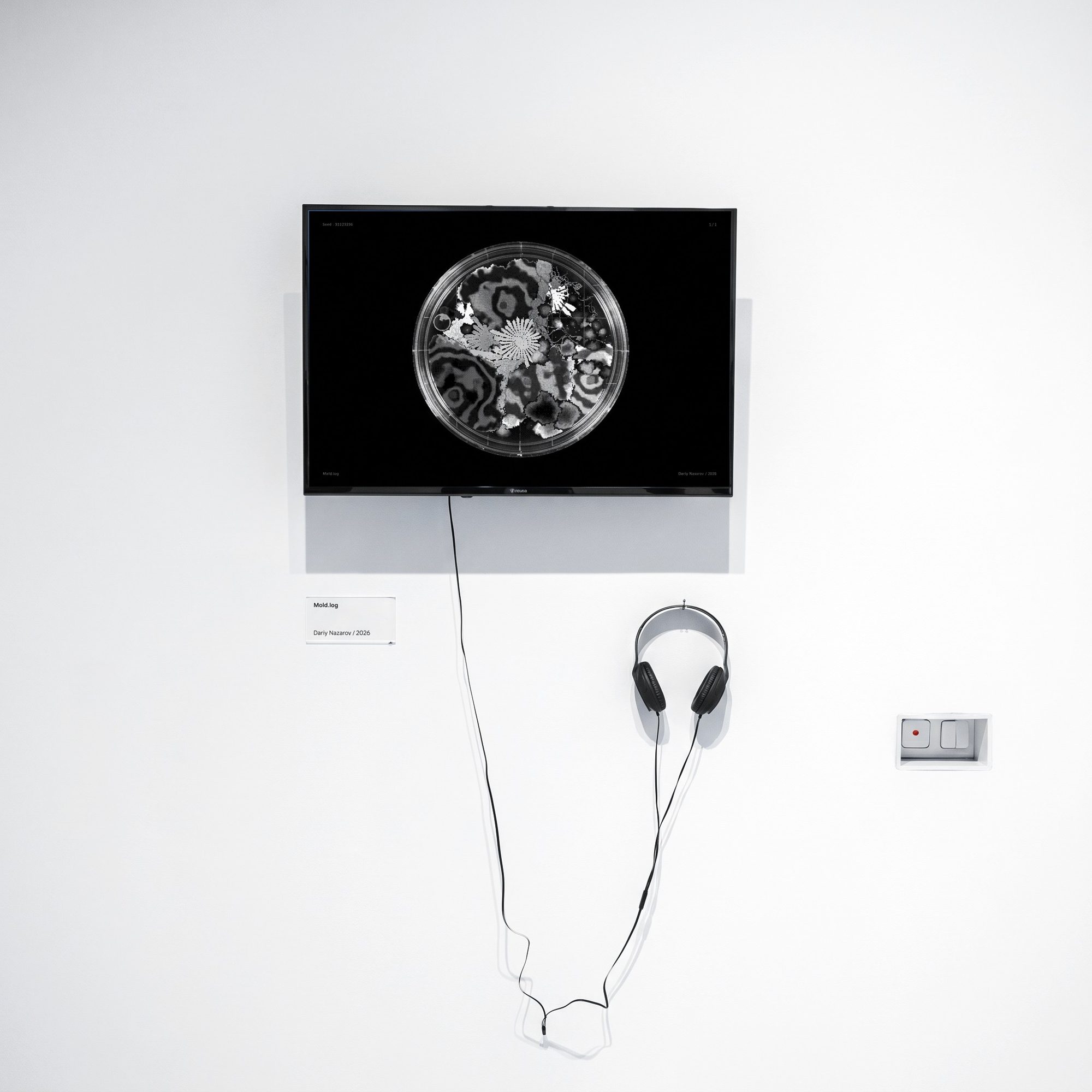 Mold.log installed on a wall screen with headphones and a label