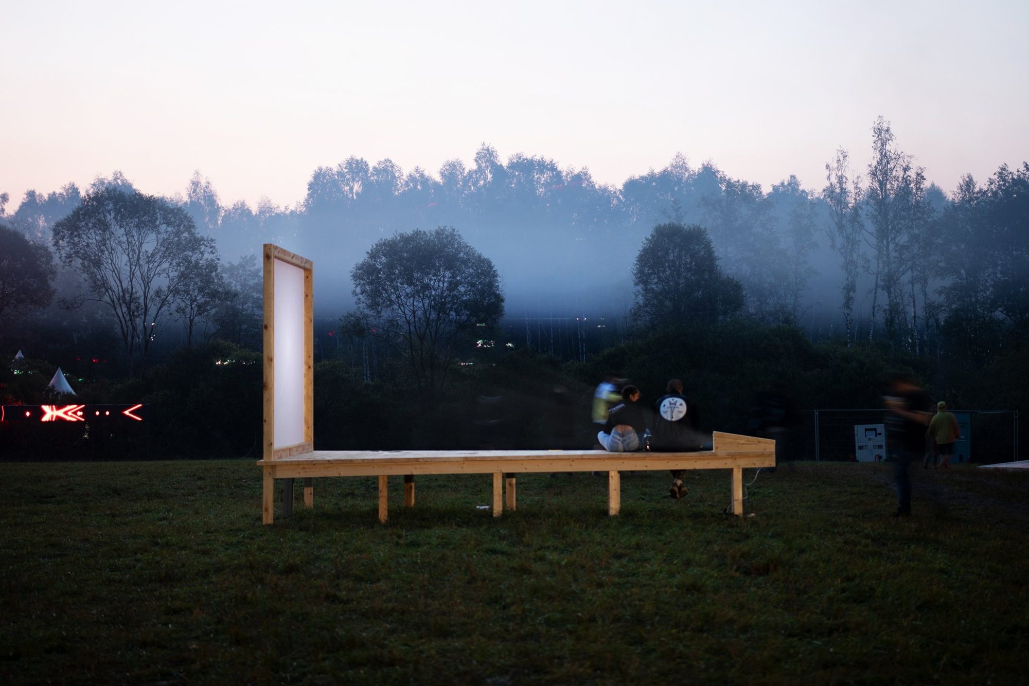 Screen pavilion in a field at dusk