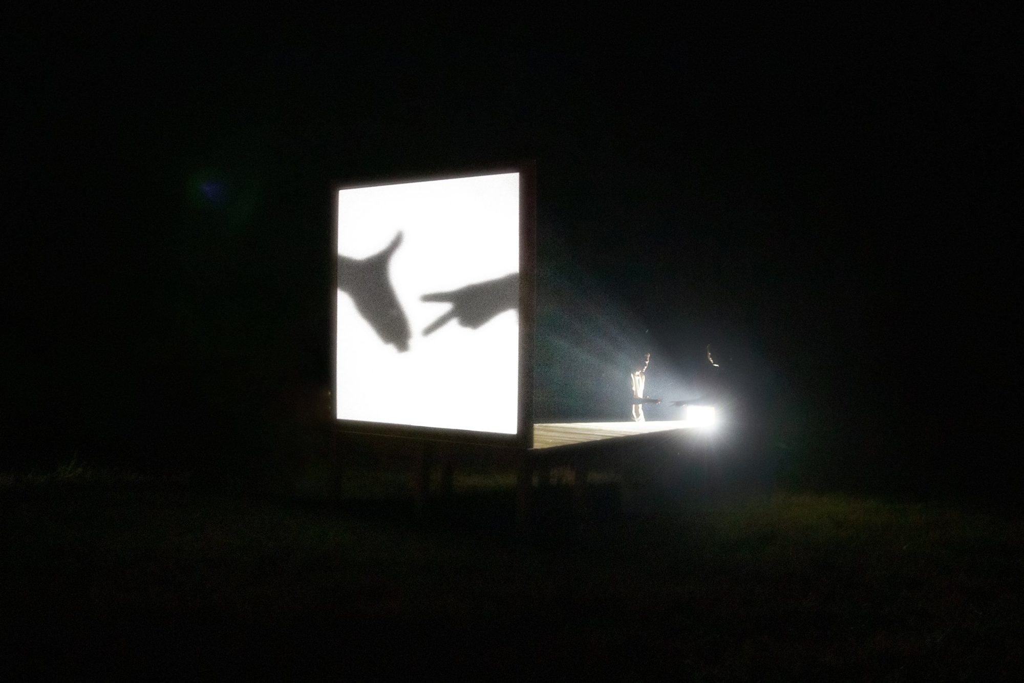 Hands casting shadows on the screen